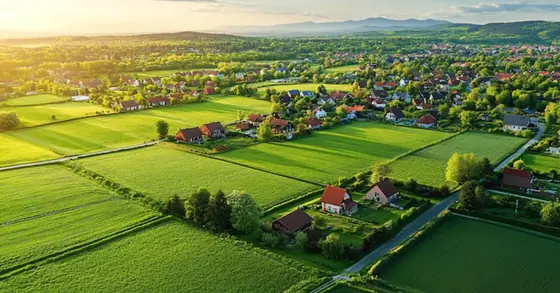Aerial illustration of plotted land with village houses nearby, shown for KNS Wilona